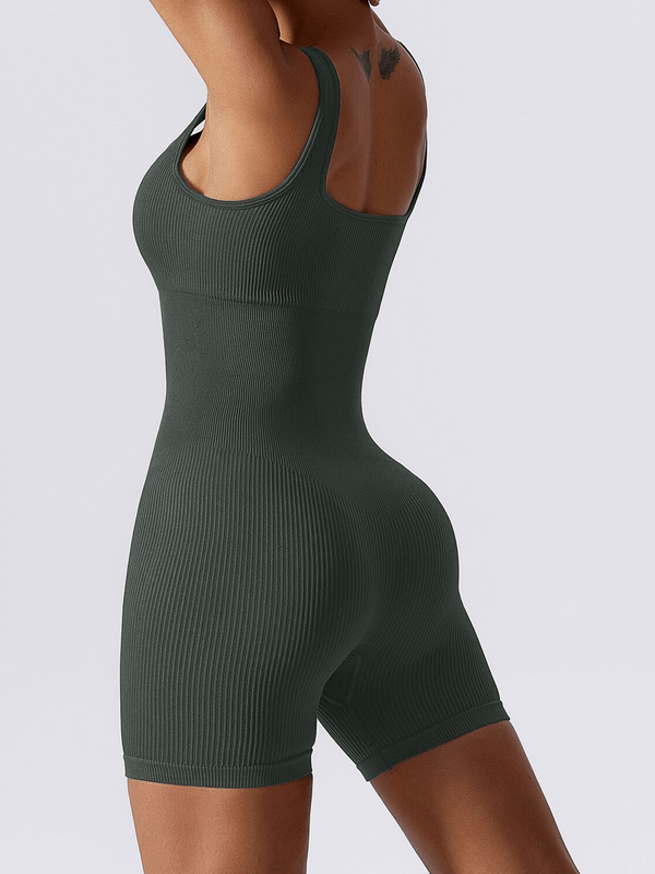 Woman wearing seamless one piece short yoga suit, black, breathable, for active lifestyle.